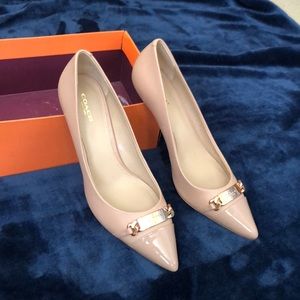 Coach pump in neutral with gold accessory.